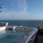 Daydreamer, a luxury beach hut rental at Freathy Cliff, Whitsand Bay, Cornwall, features an outdoor hot tub and decking area. Photo by © Unique Home Stays (uniquehomestays.com, 01637 881183)