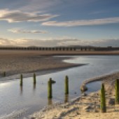 Wooden posts on the sandy shore at Arnside, Cumbria, England. Photo: Kevin Eaves/Shutterstock
