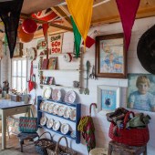 An eclectic jumble of artwork and second-hand furniture fill the hut