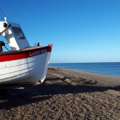 A fishing boat hauled onto the beach, fishermen fish for lobster and crab here