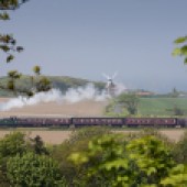 A train steams through the North Norfolk countryside near Cley Windmill