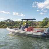 A boat on water with woodland in the background shore