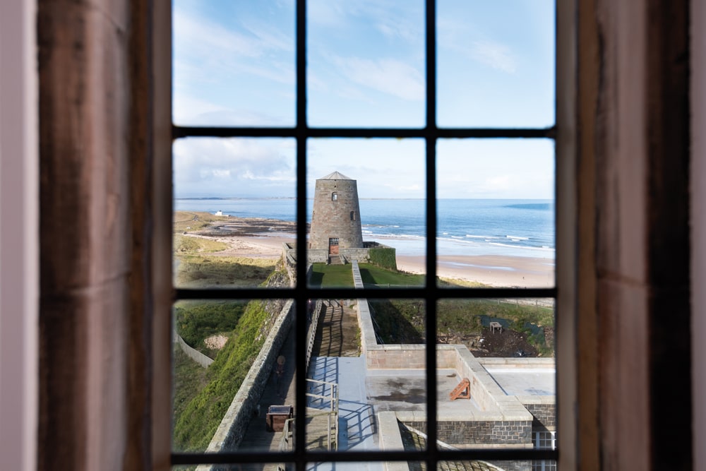 A view of the castle’s windmill and Bamburgh Beach