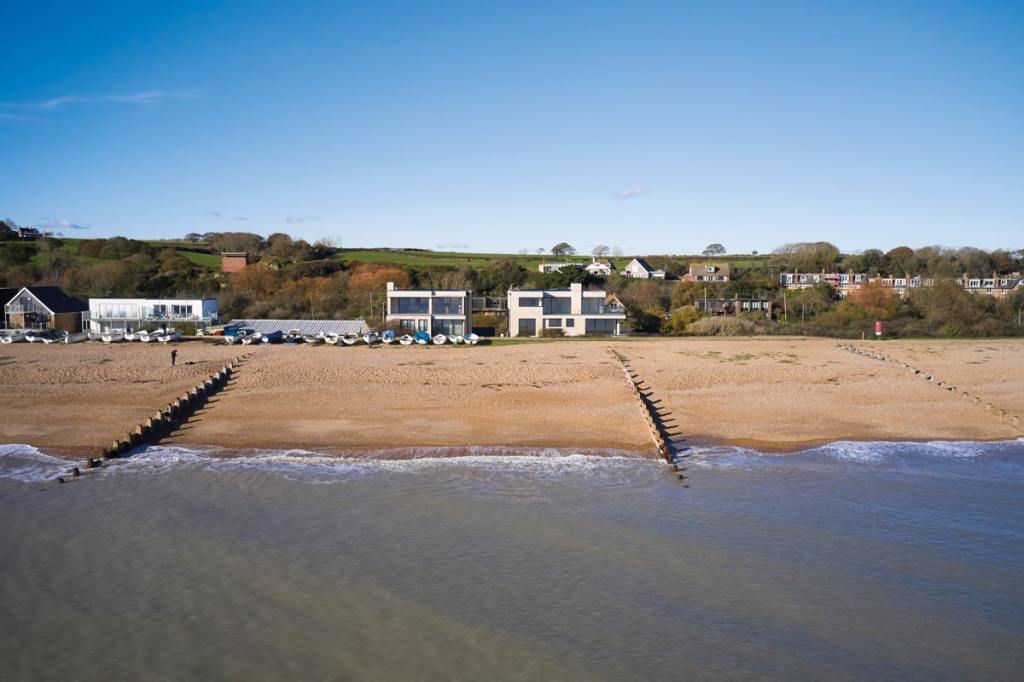 A view from the shore towards the properties and the countryside behind them