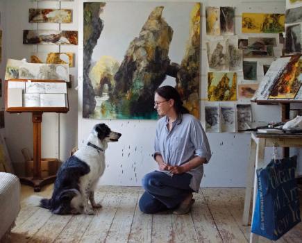 Sarah in her daylit studio, surrounded by the preliminary sketches and smaller paintings she uses as reference for a larger piece. She shares a moment with canine companion Dab, who often accompanies her on her explorations of Cornwall – the collie is ‘not a fan of waves, but keen on a good cliff walk. Photography Harmony Murt