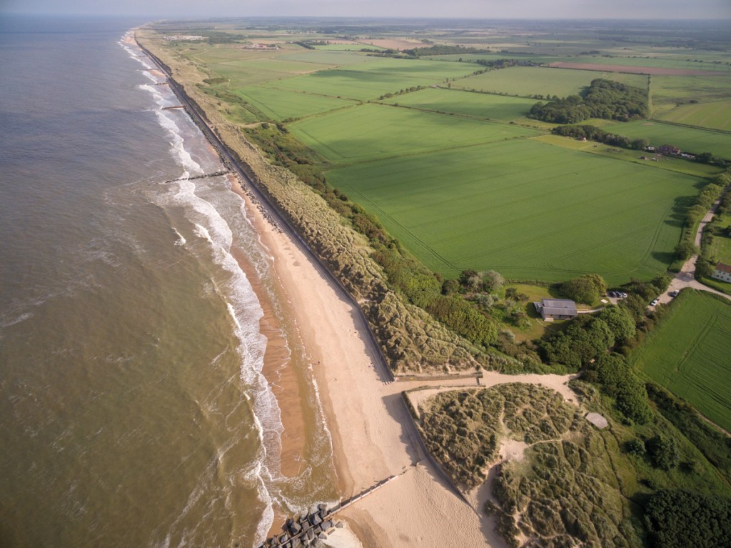 An aerial view of the property – and the beach which stretches for miles in both directions
