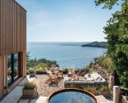 The outdoor area boasts a cedar spa tub and panoramic sea views